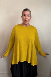 North Star Base by gertie 1153 Long Angle Tee, a relaxed long-sleeve A-line slub-knit top with a wide round neckline and flowing hem, shown in Mustard, Black, and Dusty Denim.