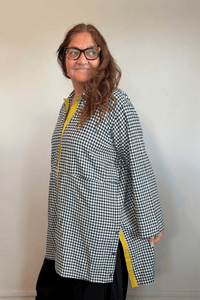 Gertie's 3078C Duster in a small-scale black-and-white check, shown from front, side, and back with an oversized longline silhouette, metal snap front, large patch pockets, and bright yellow contrast trim.