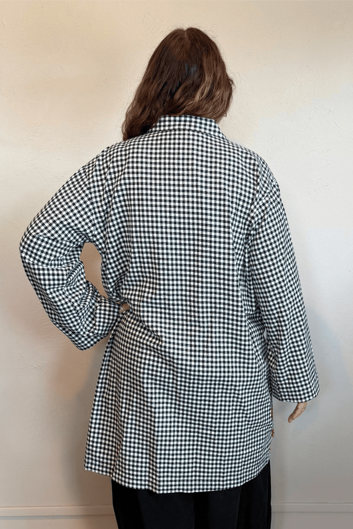 Gertie's 3078C Duster in a small-scale black-and-white check, shown from front, side, and back with an oversized longline silhouette, metal snap front, large patch pockets, and bright yellow contrast trim.