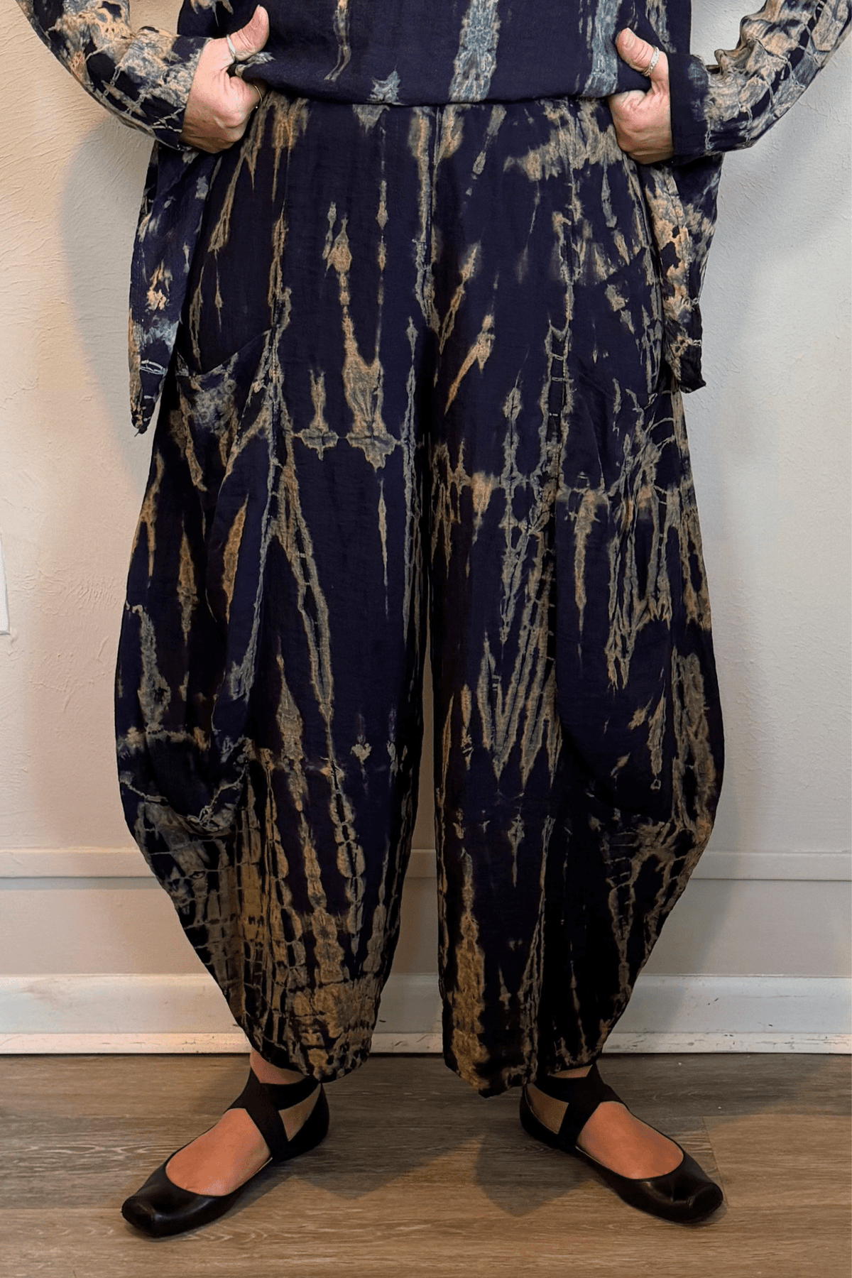 Gertie's 5092Hd Double Pocket Pant in a deep indigo hand-dyed pattern with sage, teal, ochre and muted plum accents, featuring a pull-on waist, large front patch pockets and rounded barrel-leg silhouette.