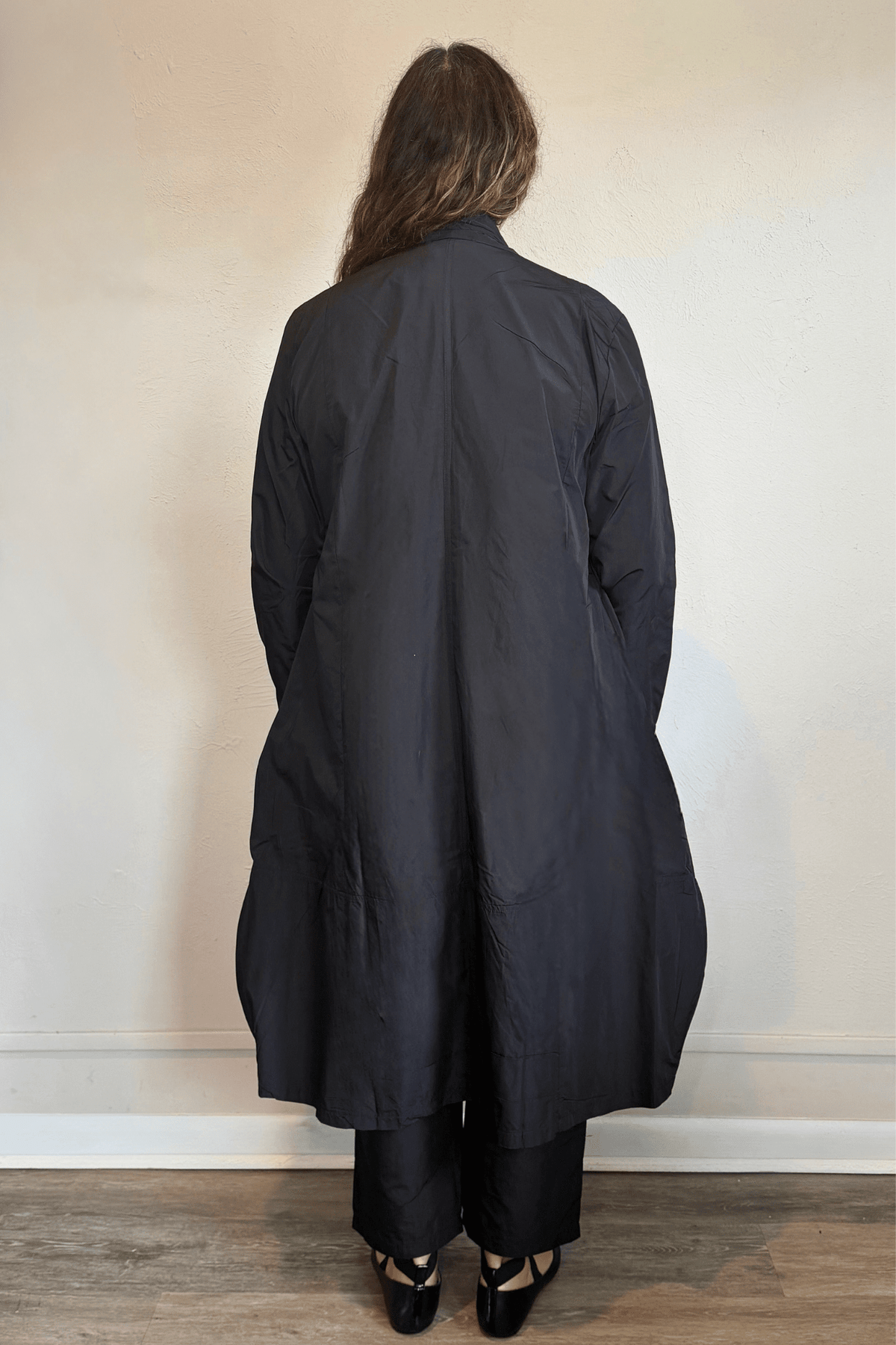 Kozan Aria Jacket in Jet black, a longline jacket with narrow lapels, single-button front, long sleeves, and oversized curved patch pockets.