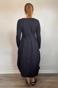 Kozan FT-11096 Via Dress in Nile, shown from front, side, and back with a V-neck, long sleeves, sculptural rounded midi silhouette, and crinkled contrast side panels.