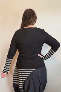 Kozan Merci Tee with a solid black body, round neckline, long sleeves, and extended black-and-gray striped contrast cuffs.