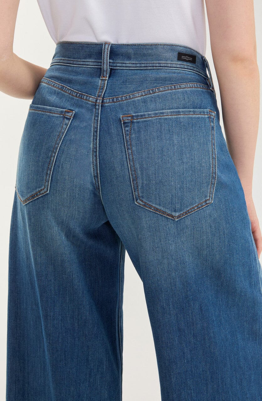 Medium blue high-rise relaxed wide-leg jeans with a full-length silhouette, belt loops, five-pocket styling, zip fly with button closure, and subtle fading.