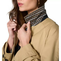 Tan raglan-sleeve coat with a straight relaxed silhouette, front button closure, angled welt pockets, long sleeves with button-tab cuffs, contrast houndstooth stand collar, and a center back inverted pleat with buttoned tab detail.