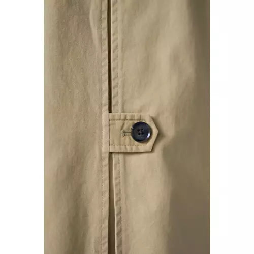 Tan raglan-sleeve coat with a straight relaxed silhouette, front button closure, angled welt pockets, long sleeves with button-tab cuffs, contrast houndstooth stand collar, and a center back inverted pleat with buttoned tab detail.