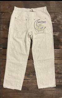Jaded Gypsy Parchment Peace And Love Jeans with distressed details, PEACE leg graphic, floral artwork, and embroidered back design