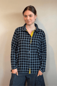 Gertie's 2077B Plackett Gussett Top, a blue-and-black check flannel shirt with long sleeves, metal front snaps, contrasting check side gussets, and yellow placket trim.