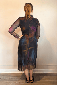 Kozan SH-11058 Mack Dress in Loden, shown from front and back with abstract painterly print, sheer long sleeves, high neckline, and layered asymmetrical midi hem.