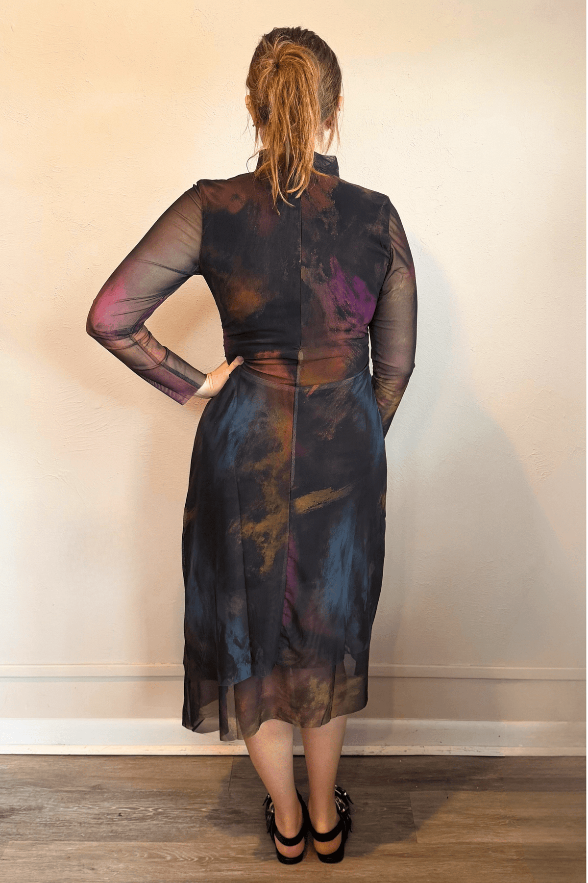 Kozan SH-11058 Mack Dress in Loden, shown from front and back with abstract painterly print, sheer long sleeves, high neckline, and layered asymmetrical midi hem.