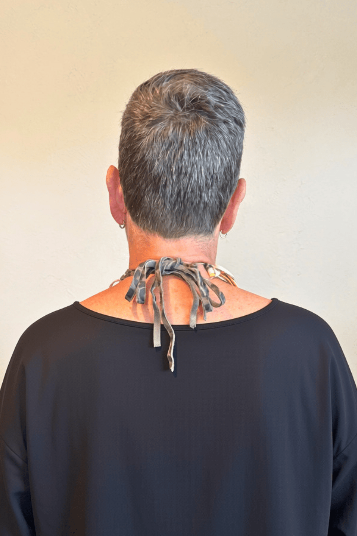 A Rare Bird Painter's Palette Layered Necklace, a wide bib-style statement necklace with layered paint-marked brushes, colorful beads, chains, dangling artist-inspired objects, and long mixed leather fringe ties.