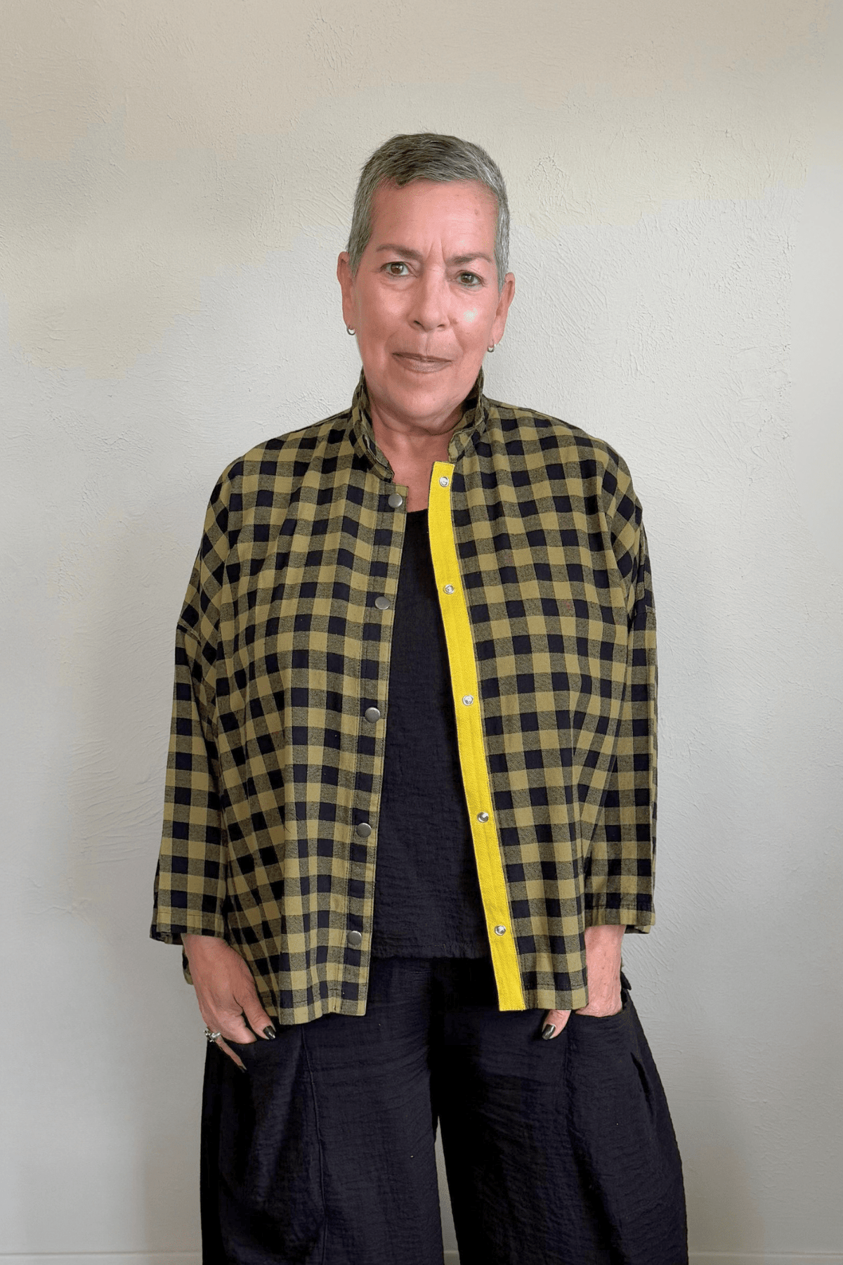 Gertie's 2165B Big Shirt in olive-and-black check cotton flannel, with a relaxed boxy silhouette, point collar, three-quarter sleeves, metal snap front, and bright yellow contrast placket trim.