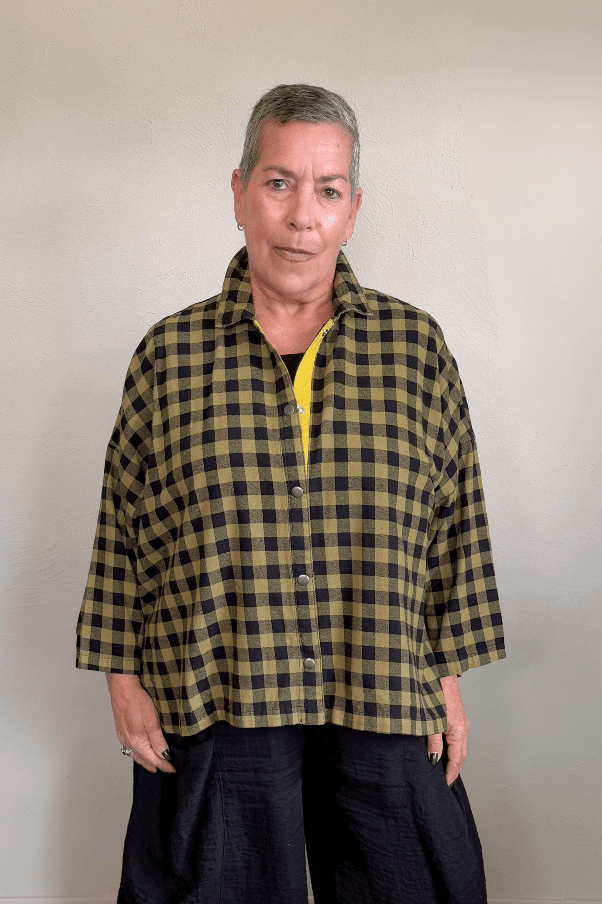 Gertie's 2165B Big Shirt in olive-and-black check cotton flannel, with a relaxed boxy silhouette, point collar, three-quarter sleeves, metal snap front, and bright yellow contrast placket trim.