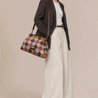 American Leather Co. Grace Oversized Clutch with woven leather patchwork, vintage-inspired kisslock frame, and removable crossbody strap.