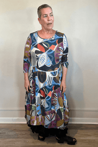 Model wearing the Kozan Demi maxi dress with an allover multicolor abstract print, scoop neckline, three-quarter sleeves, and flowing A-line skirt, shown from front and back.