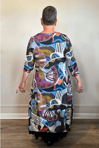 Model wearing the Kozan Demi maxi dress with an allover multicolor abstract print, scoop neckline, three-quarter sleeves, and flowing A-line skirt, shown from front and back.