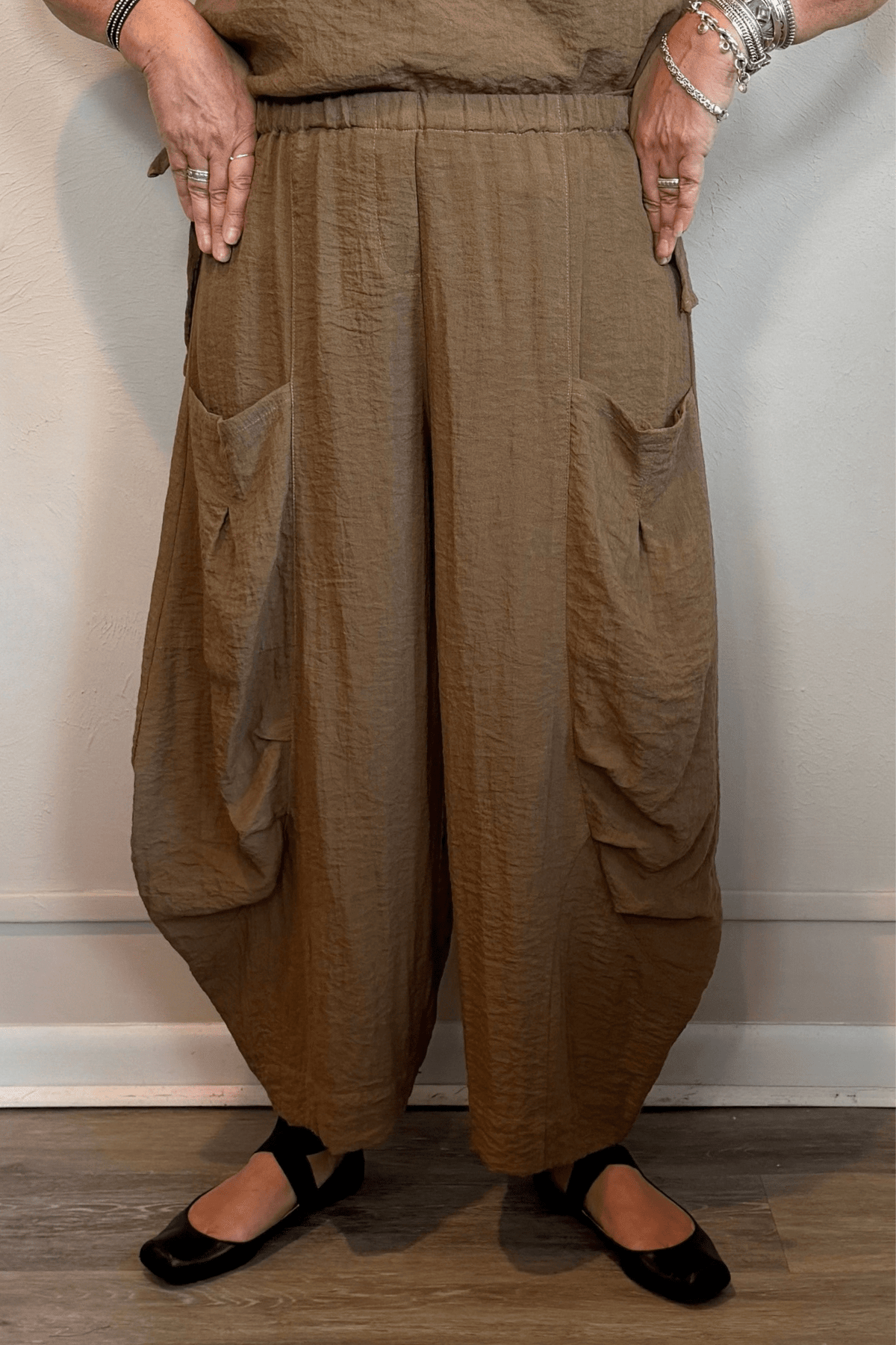 Gertie's 5080 Double Pocket Pant in Winter Olive and Indigo, shown from front and back with a relaxed barrel-leg silhouette, elastic waist, oversized patch pockets, and crinkled texture.