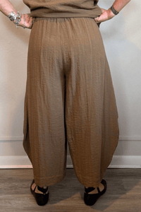 Gertie's 5080 Double Pocket Pant in Winter Olive and Indigo, shown from front and back with a relaxed barrel-leg silhouette, elastic waist, oversized patch pockets, and crinkled texture.