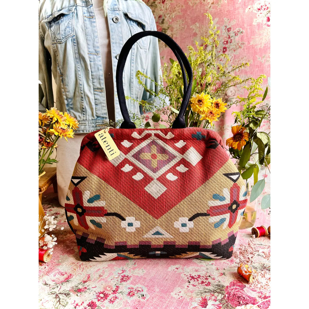 Atenti Eagle Molly Snap Frame Bag with Southwest-inspired woven geometric and floral pattern, dark double handles, and structured snap-frame silhouette.