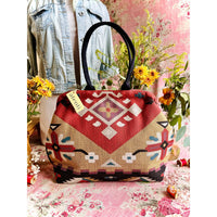 Atenti Eagle Molly Snap Frame Bag with Southwest-inspired woven geometric and floral pattern, dark double handles, and structured snap-frame silhouette.