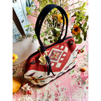 Atenti Eagle Molly Snap Frame Bag with Southwest-inspired woven geometric and floral pattern, dark double handles, and structured snap-frame silhouette.