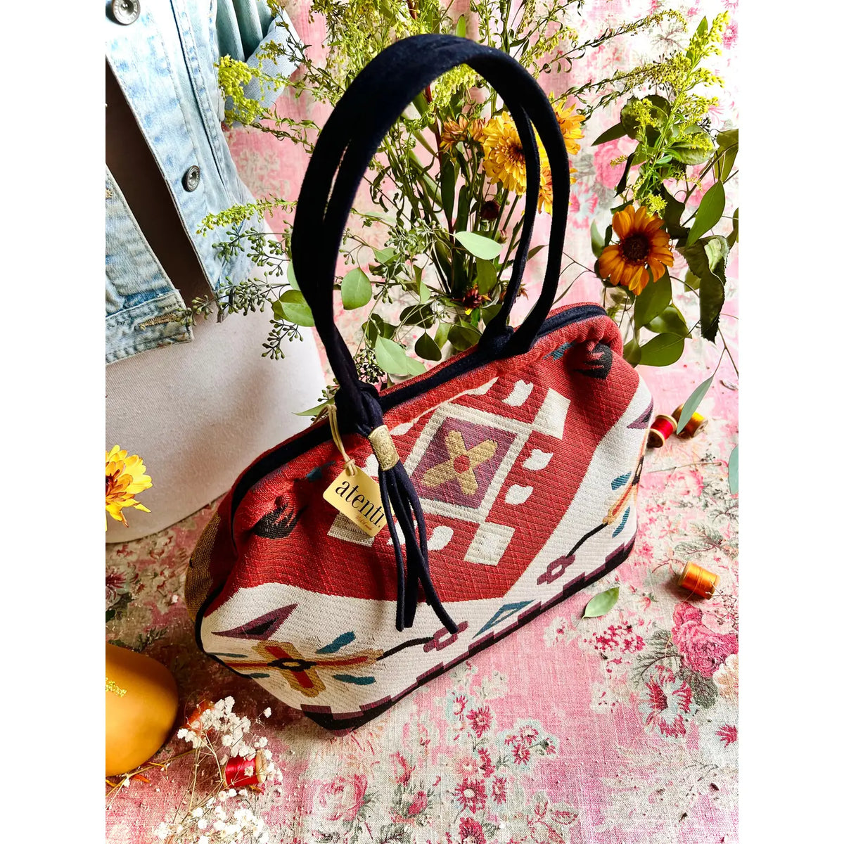 Atenti Eagle Molly Snap Frame Bag with Southwest-inspired woven geometric and floral pattern, dark double handles, and structured snap-frame silhouette.