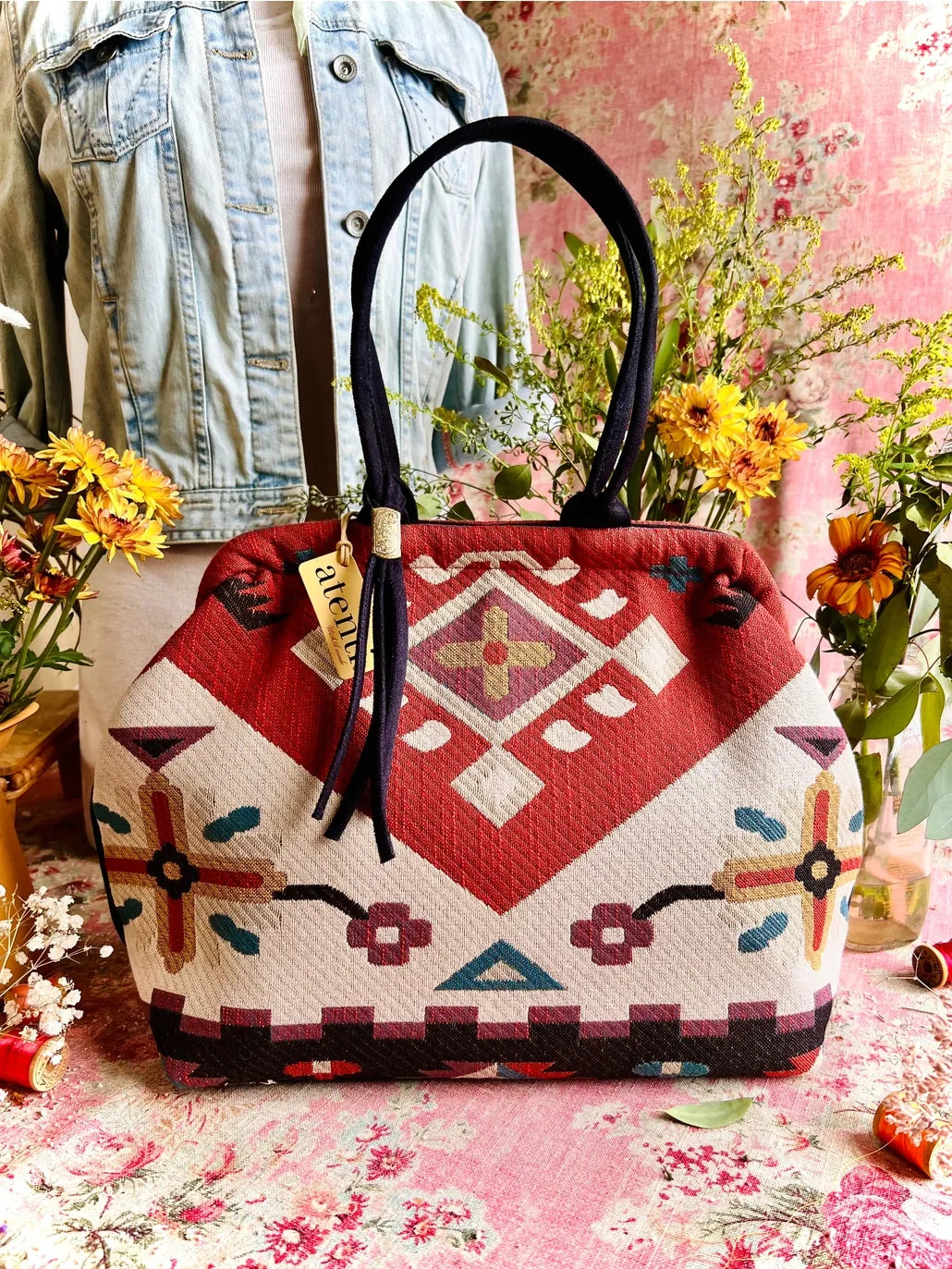 Atenti Eagle Molly Snap Frame Bag with Southwest-inspired woven geometric and floral pattern, dark double handles, and structured snap-frame silhouette.