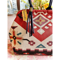 Atenti Eagle Molly Snap Frame Bag with Southwest-inspired woven geometric and floral pattern, dark double handles, and structured snap-frame silhouette.