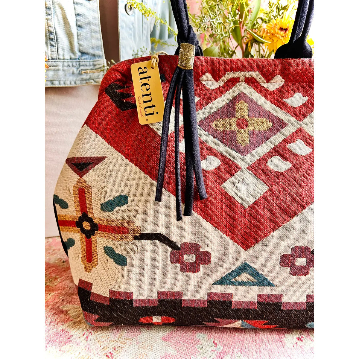 Atenti Eagle Molly Snap Frame Bag with Southwest-inspired woven geometric and floral pattern, dark double handles, and structured snap-frame silhouette.