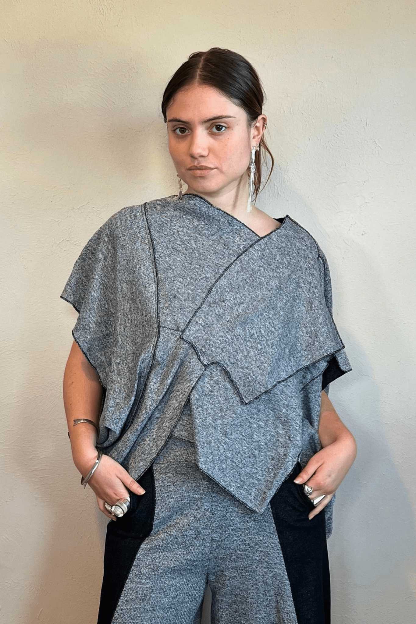 Model wearing the Kozan Fari draped top in heathered gray with black contrast edging, shown from front and back, including a full outfit view with coordinating pants.
