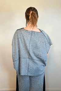 Model wearing the Kozan Fari draped top in heathered gray with black contrast edging, shown from front and back, including a full outfit view with coordinating pants.