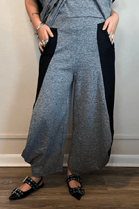 Model wearing the Kozan Jade Pant in heathered gray with black contrast side panels, shown from front, side, and back to highlight the lantern-leg silhouette and curved side pockets.