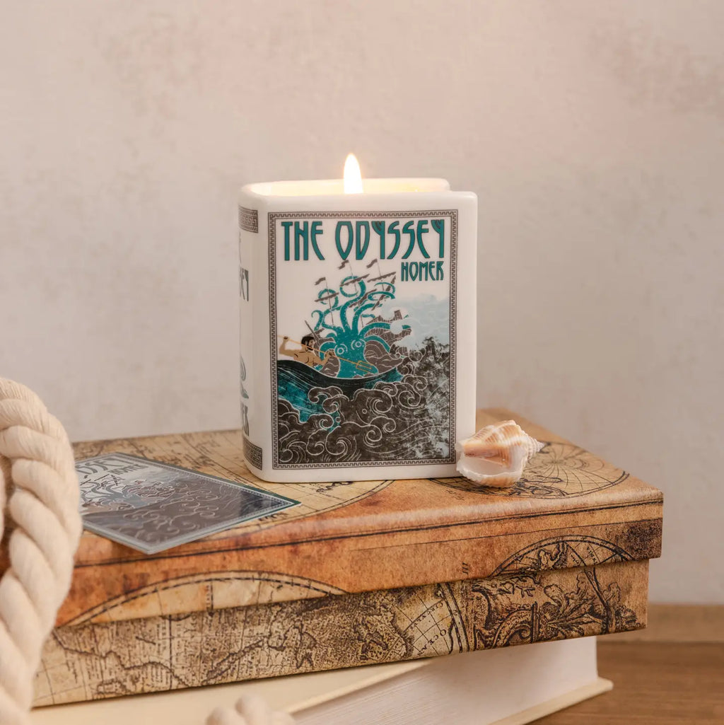 Steel Mill & Co. The Odyssey Book Candle in decorative ceramic book-shaped vessel, showing artwork, sides, and lit candle