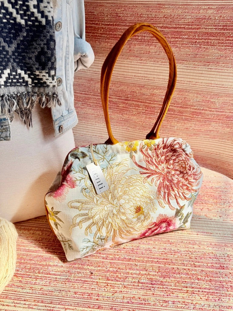 Atenti Primrose Molly handbag with oversized floral print, caramel-colored double handles and base, and structured snap-frame silhouette