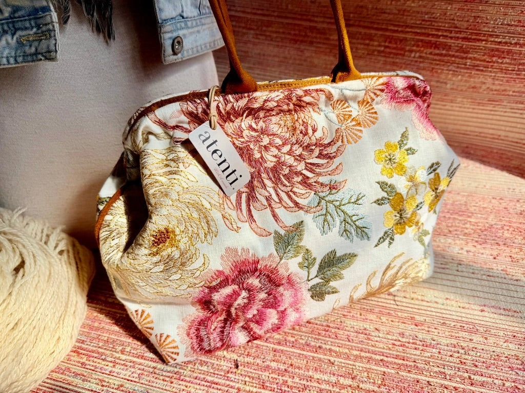 Atenti Primrose Molly handbag with oversized floral print, caramel-colored double handles and base, and structured snap-frame silhouette