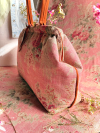 Atenti Rosewood Pioneer handbag with faded rose print, caramel double handles and piping, and contrasting caramel base with metal feet