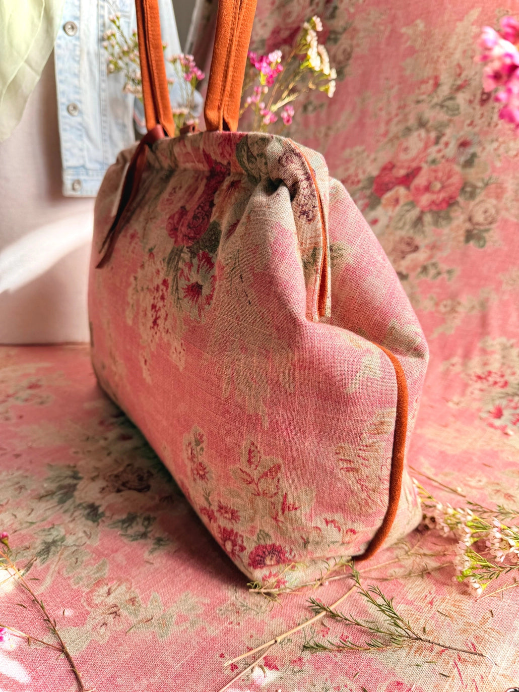 Atenti Rosewood Pioneer handbag with faded rose print, caramel double handles and piping, and contrasting caramel base with metal feet