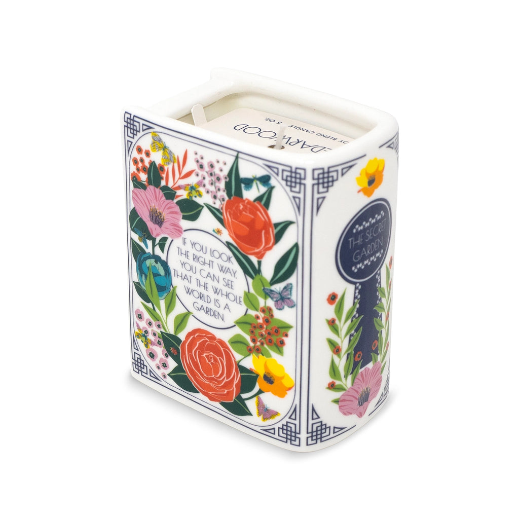 Steel Mill & Co. The Secret Garden Book Candle featuring colorful botanical illustrations in a ceramic book-shaped vessel