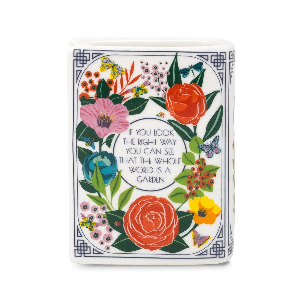 Steel Mill & Co. The Secret Garden Book Candle featuring colorful botanical illustrations in a ceramic book-shaped vessel