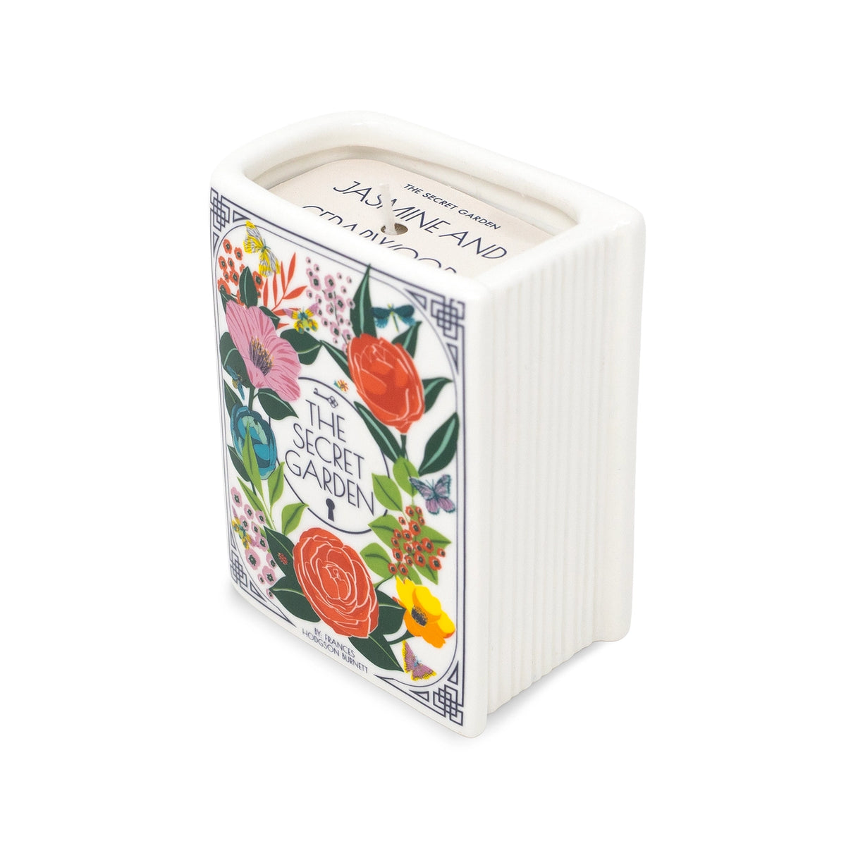 Steel Mill & Co. The Secret Garden Book Candle featuring colorful botanical illustrations in a ceramic book-shaped vessel