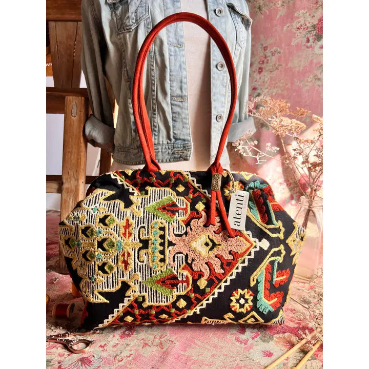 Atenti Sew Crewel Molly handbag with multicolor crewel-style embroidery, bright red double handles, and structured snap-frame silhouette