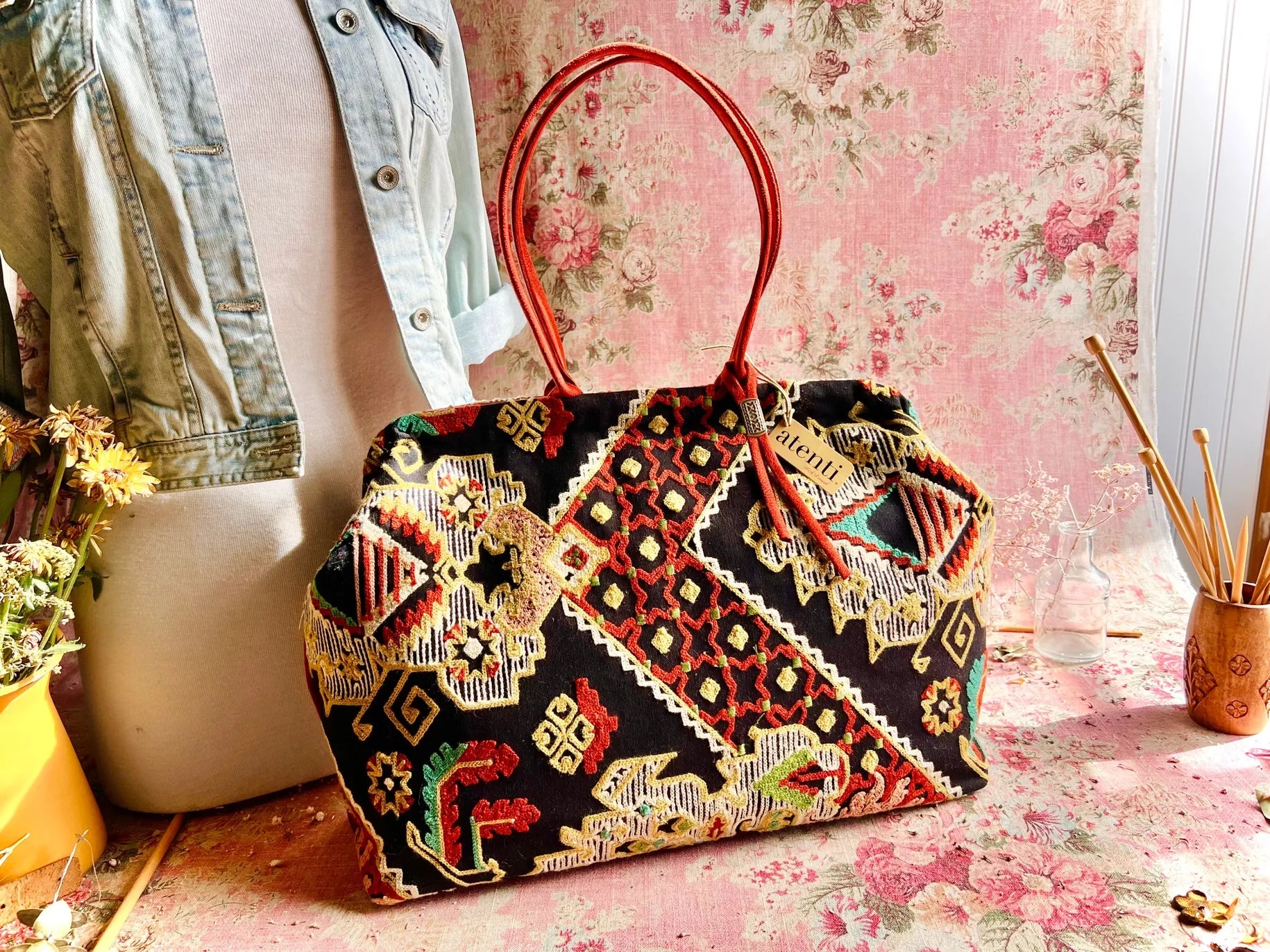 Atenti Sew Crewel Pioneer handbag with multicolor crewel-style embroidery, bright red double handles, and structured snap-frame silhouette