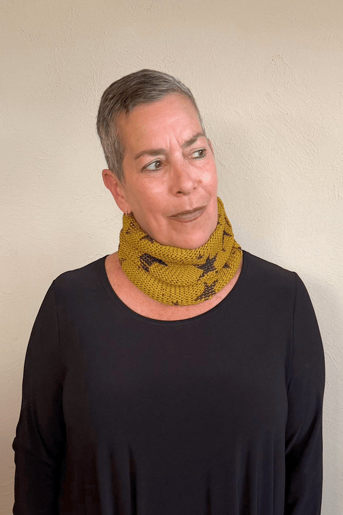 Paper Temples Star Knitted Neck Piece in mustard with charcoal print worn as a neck warmer