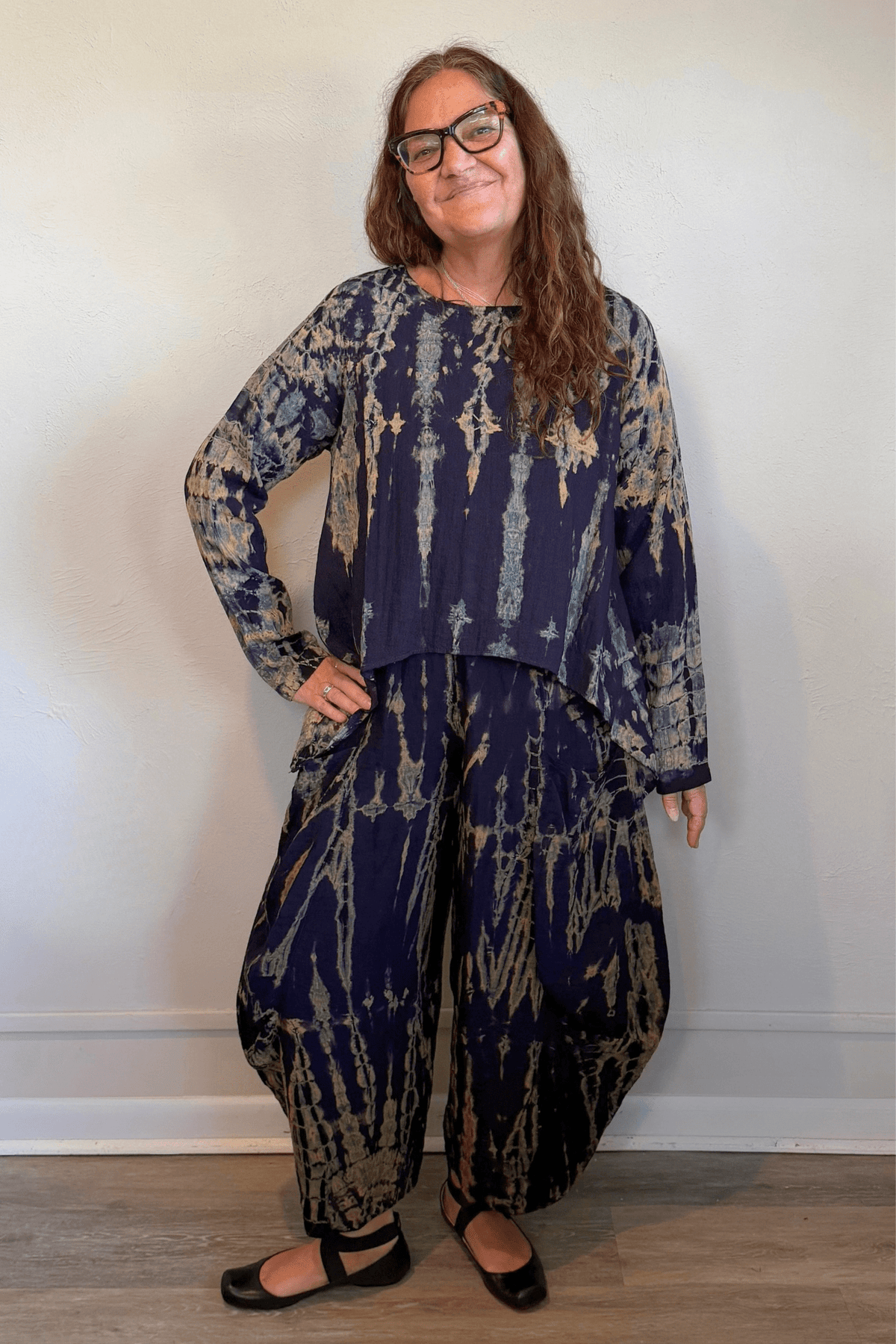 Gertie's 1073Hd Topper in a deep indigo hand-dyed pattern with sage, teal, ochre and muted plum accents, featuring long sleeves, a relaxed silhouette and asymmetrical handkerchief-style hem.